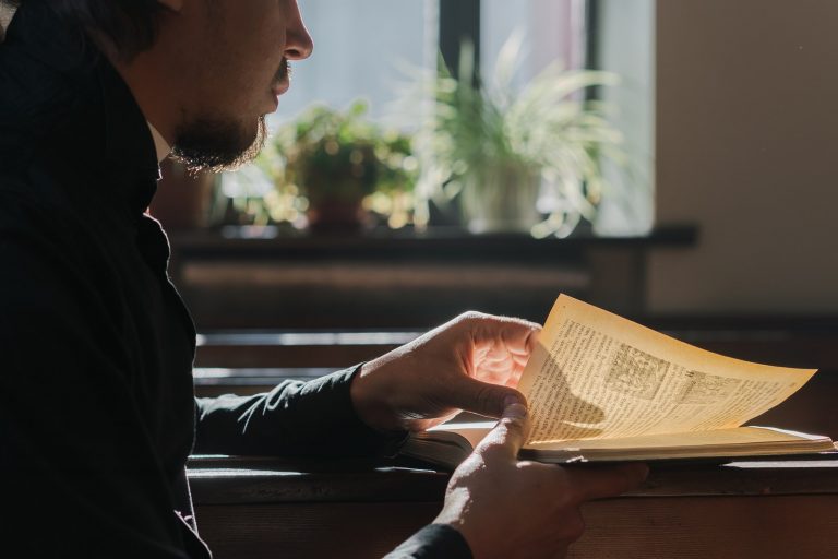 A Man Reading a Religious Book