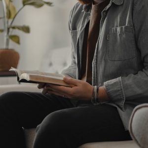 woman in blue denim jacket and black pants sitting on couch