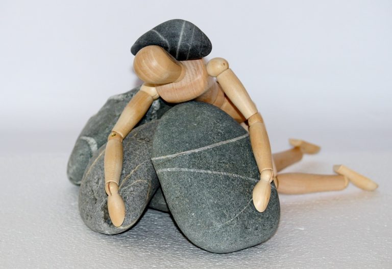 wooden figure, stones, struggle for life