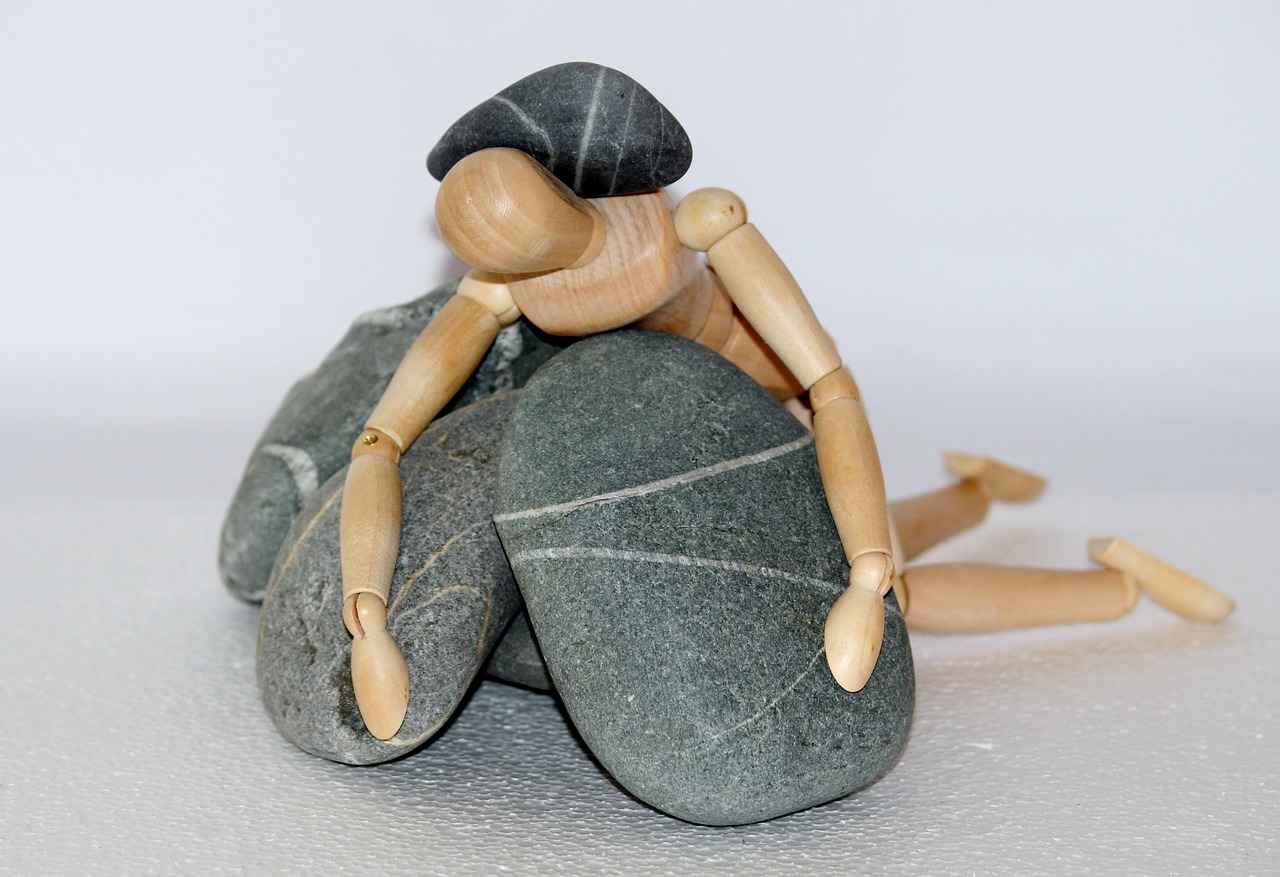 wooden figure, stones, struggle for life