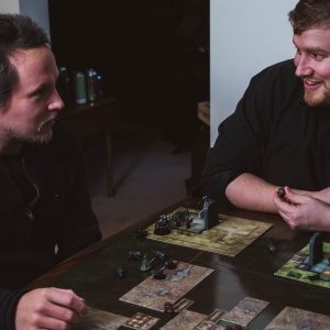 two men sitting at a table playing a game
